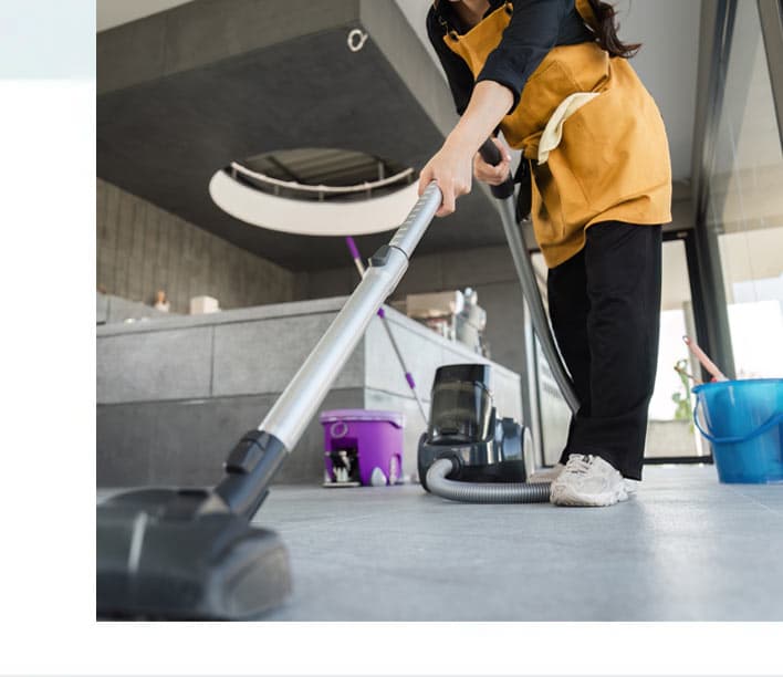 Auf dem Bild ist eine Person mit Staubsauger zu sehen.